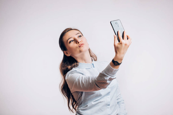 Cute brunette takes a selfie on a smartphone - Fotoğraf, Görsel