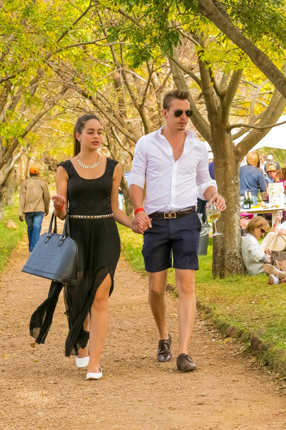 Johannesburg, South Africa, 05/10/2014,  Young couple walking hand in hand at The Winter Sculpture Fair at Nirox Sculpture Park - Foto, imagen
