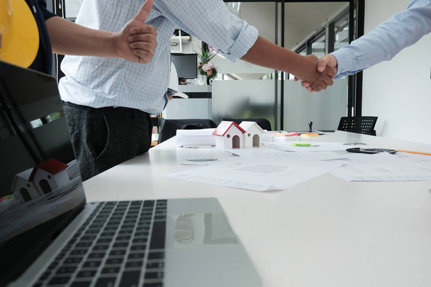 architect & customer shaking hands at workplace. Engineer handshaking with partner for successful deal in building project development. business teamwork concept - Photo, Image