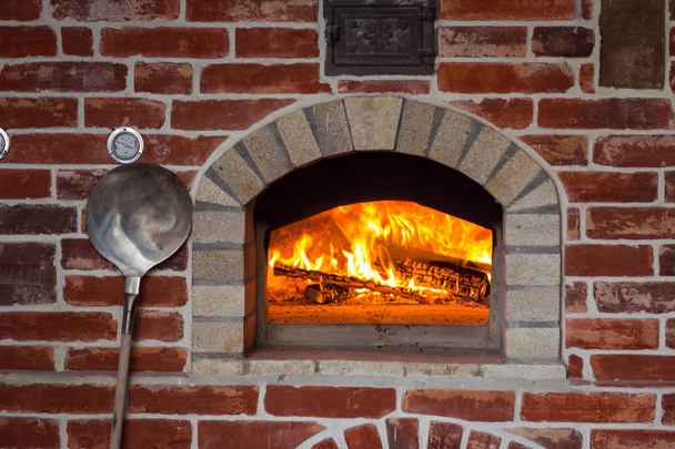 Традиционная итальянская печь для пиццы, горящее дерево и пламя в камине
 - Фото, изображение