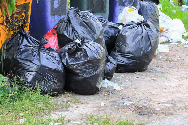 Pile sac poubelle noir au bord de la route dans la ville
 - Photo, image