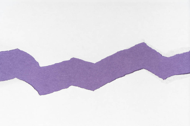 a sheet of torn paper over a colored surface - Fotó, kép