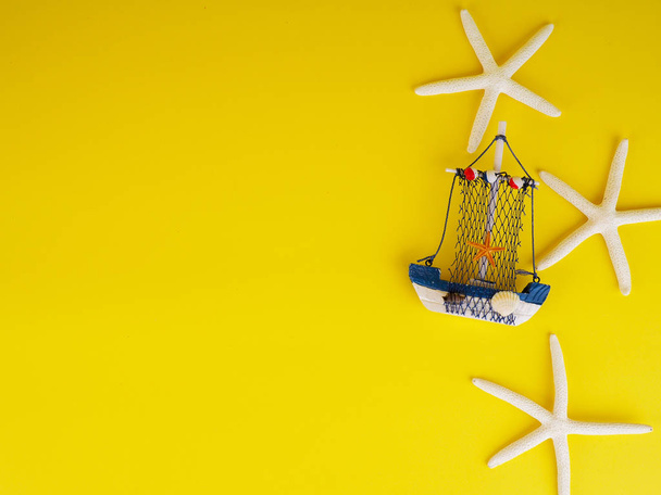 Vintage sailing boat ship on yellow. Wooden marine miniature, handmade souvenirs, minimalism is the concept of vacation. - Photo, Image