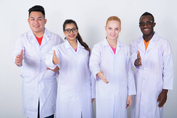 Studioaufnahme einer fröhlichen, vielfältigen Gruppe multiethnischer Ärzte, die lächeln - Foto, Bild