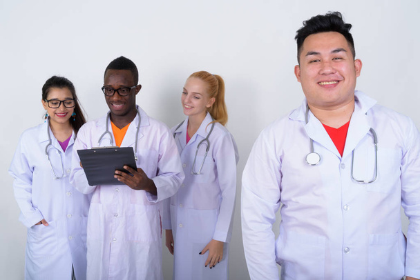 Studio shot of happy young Asian man doctor with diverse group o - Photo, Image