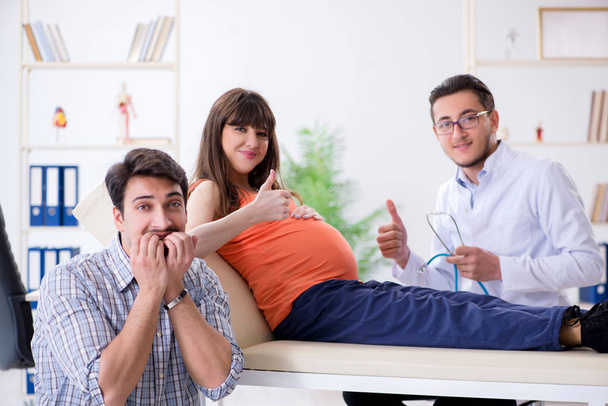 Pregnant woman with her husband visiting the doctor in clinic - Photo, Image