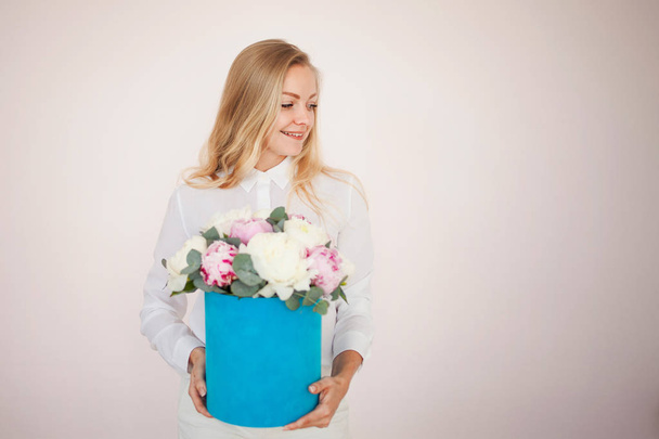 Stylish flower delivery, gift. Woman with flowers in a hat box. Bouquet of peonies. - Fotografie, Obrázek