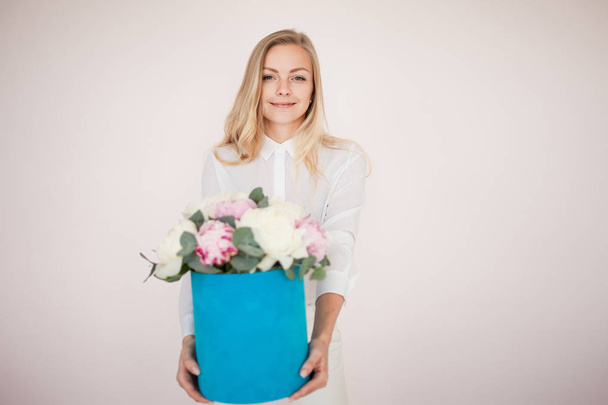 Stylish flower delivery, gift. Woman with flowers in a hat box. Bouquet of peonies. - Fotoğraf, Görsel