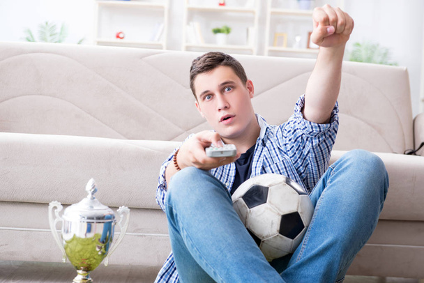 Юноша смотрит футбол дома - Фото, изображение