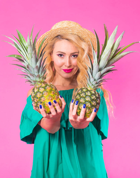 Fashion portrait young beautiful woman with pineapple over pink background - Photo, Image