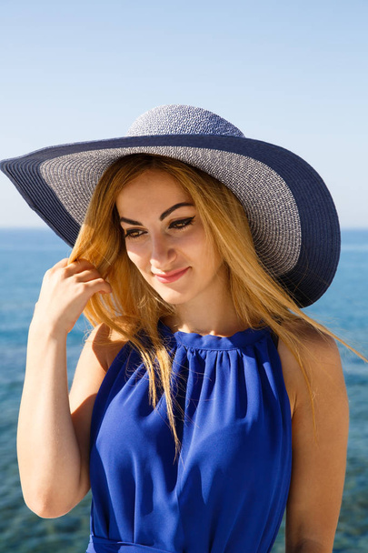 hübsche blonde Frau im blauen Kleid am Strand von Zypern. - Foto, Bild