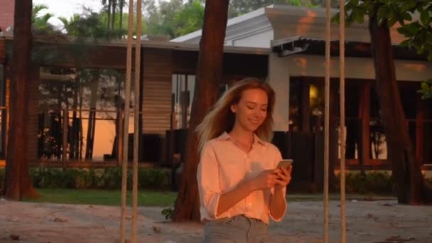 Lento movimento futuro professor feminino mensagens de texto com namorado perto de cabana de verão
 - Filmagem, Vídeo