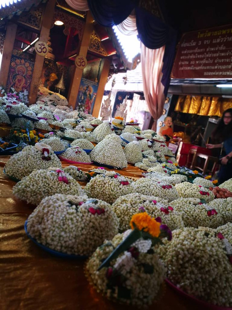 egy csomó garland jázmin virágok Játssz Buddha szobor, a templomban az Észak-thaiföldi Wat Phra hogy Doi Kham (az arany-hegy temploma) Chiang Mai - Fotó, kép