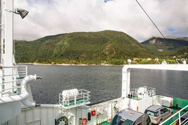 Landschaft mit Bergen, Fjord und Dorf in Norwegen. Blick vom Kreuzfahrtschiff. - Foto, Bild