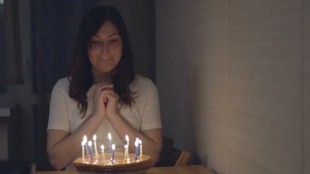 schöne Frau bläst Kerzen auf einer festlichen Torte aus - Filmmaterial, Video