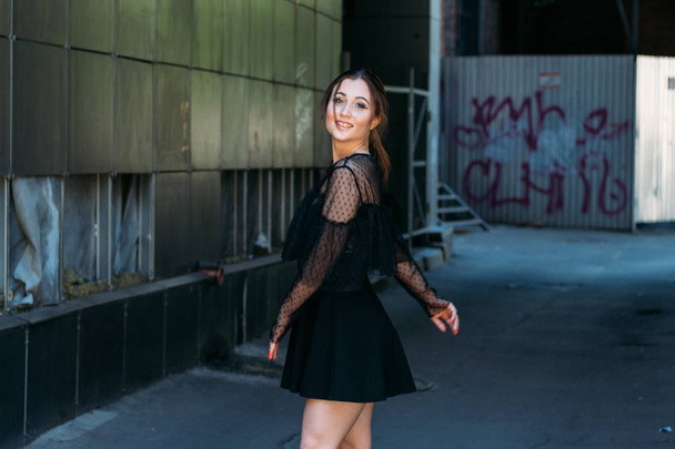 Emotional portrait of Fashion stylish portrait of pretty young woman. city portrait. sad girl. brunette in a black dress with stars and planets on a dress. expectation. dreams. beautiful brunette whirls around in the city. happy and cheerful. black d - Fotografie, Obrázek