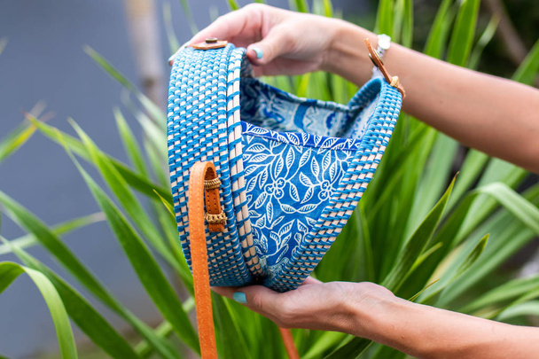 Fashionable stylish rattan bag on a tropical background. Tropical island of Bali, Indonesia. Rattan handbag. - Foto, Imagen