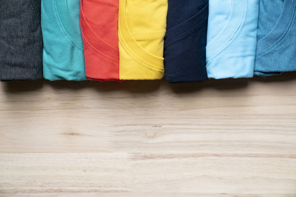 close up of rolled colorful clothes on table background - Photo, Image
