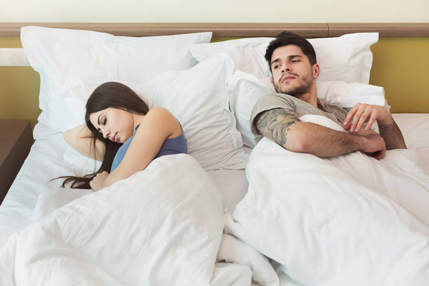 Aviomies katselee vaimoa, kun hän nukkuu riidan jälkeen
 - Valokuva, kuva