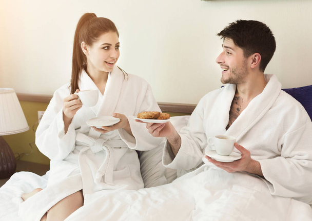 ホテルの部屋で朝食を持っている若い夫婦 - 写真・画像