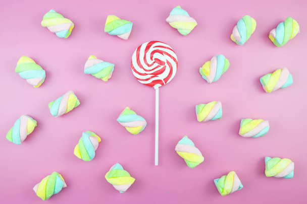 Flat lay top view tasty appetizing concept, minimal Sweet Treat Swirl Candy Lollipop marshmallow Colorful pattern on pink pastel background and copy space - Φωτογραφία, εικόνα
