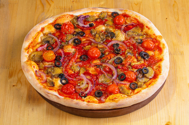 Pizza with mushrooms and tomatoes over wooden background - Photo, Image