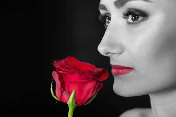 Kobieta z czerwonymi ustami makijaż przytrzymaj rose. Piękno z kwiatem. Zmysłowe piękno. Przetarg jak kwiat. Pielęgnacja skóry i spa leczenia. Walentynki-dzień i data concept. Prezent z miłości. Dzień kobiet, czarno-białe - Zdjęcie, obraz