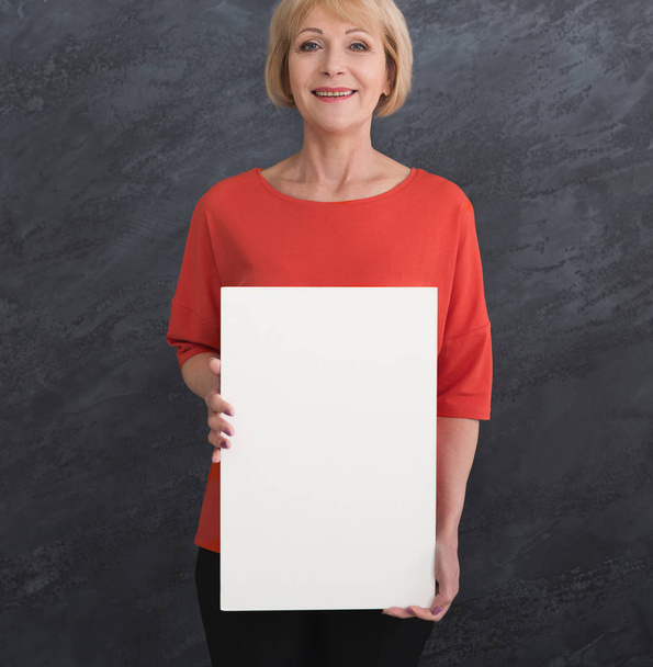 glückliche Frau mittleren Alters mit leerem weißen Papier - Foto, Bild
