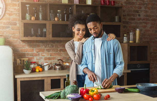 Loving african-american couple cooking in loft kitchen - Photo, Image