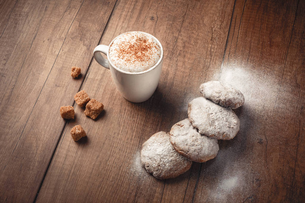 Kaffee mit Keksen und Zimt auf braunem Brett von oben - Foto, Bild