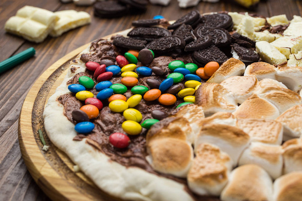 sweet pizza with chocolate and marshmallow on wooden background - Photo, Image