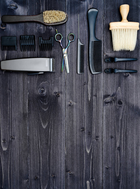 Hairdresser tools on wooden background. Top view on wooden table with scissors, comb, hairbrushes and hairclips, free space. Barbershop - Photo, image