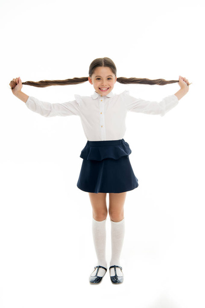 Happy kid show long brunette hair isolated on white. Fashion girl smile with new hairstyle. Proud of her beautiful hair. Hairdresser salon services for little girl. Beauty salon. Stylish and cute - Foto, imagen