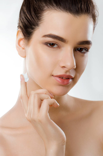 Facial Care. Female Applying Cream and Smiling. Portrait Of  Young Woman With Cosmetic Cream On Skin. Closeup Of Beautiful Girl With Beauty Product On Soft Skin, Natural Makeup Touching Face. High Resolution - Photo, Image