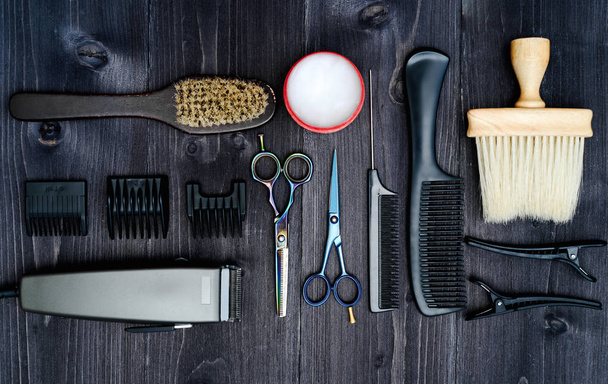 Hairdresser tools on wooden background. Top view on wooden table with scissors, comb, hairbrushes and hairclips, free space. Barbershop, manhood concept - Foto, imagen