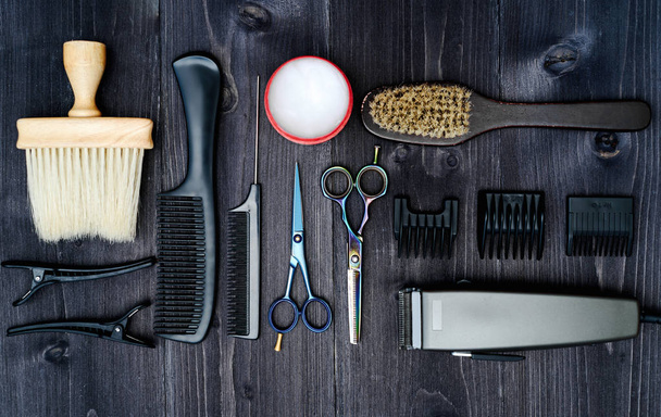 Hairdresser tools on wooden background. Top view on wooden table with scissors, comb, hairbrushes and hairclips, free space. Barbershop, manhood concept - Foto, immagini
