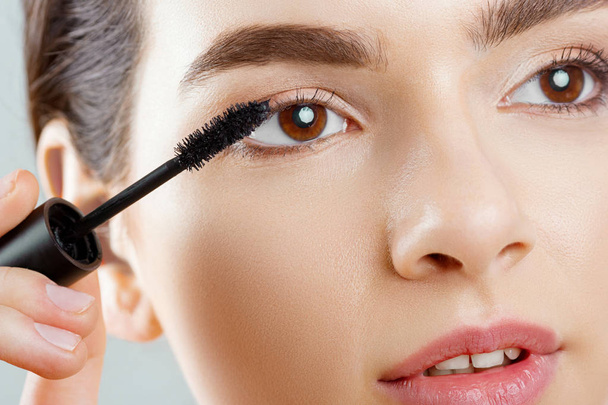 Mascara Closeup Of A Beautiful Young Woman A Face With A Beauty Makeup, Fresh Soft Skin Applying Mascara With Cosmetic Brush. Make-up And Cosmetics Concept. - Foto, imagen