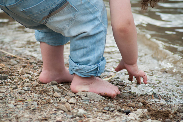closeup of feet of child playing on the beach with stone - Fotoğraf, Görsel