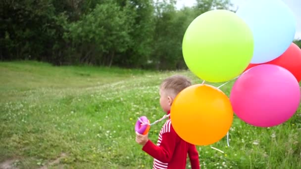Happy little baby, fun running around with balloons. Outdoor recreation. Celebration and fun.Childs birthday - Footage, Video