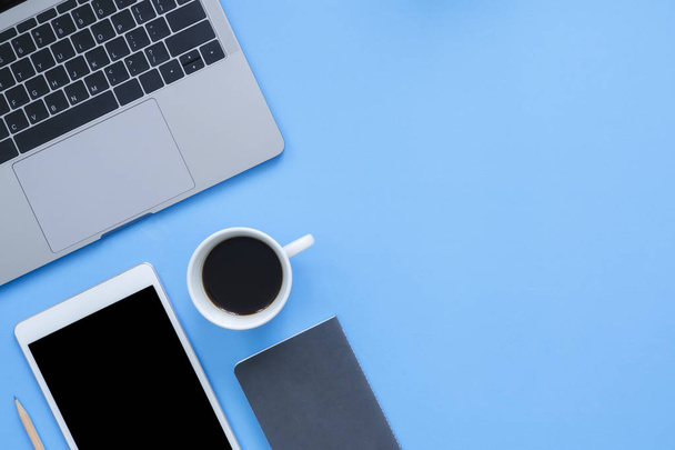 Робочий простір офісу Плоский макет зверху робочого простору з ноутбуком, смартфоном, кавою і блокнотом на синьому пастельному фоні. Концепція робочого столу пастельного синього кольору
 - Фото, зображення