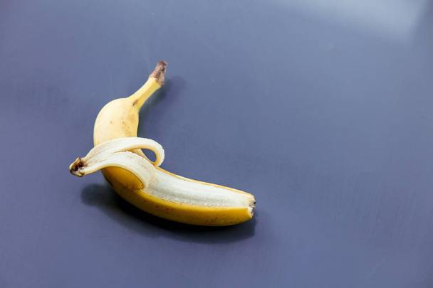 Yellow banana on grey metal background - Zdjęcie, obraz