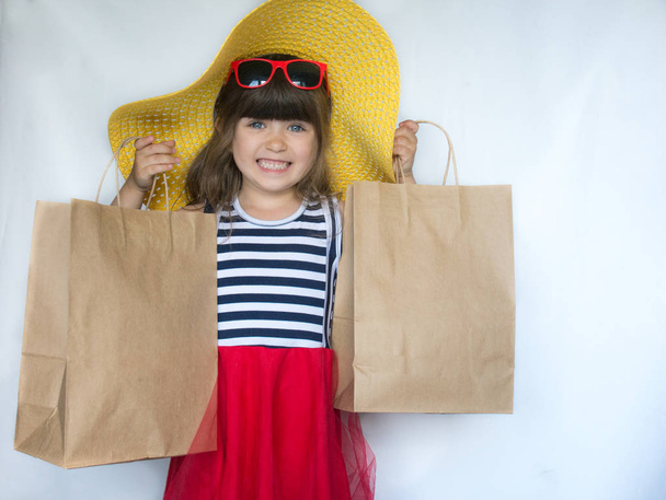 Yaz alışveriş kavramı. Küçük kız holding alışveriş torbaları. - Fotoğraf, Görsel