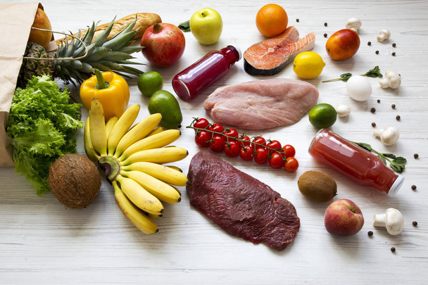 Plná taška různých zdravých potravin nad bílé dřevěné pozadí, boční pohled.  - Fotografie, Obrázek