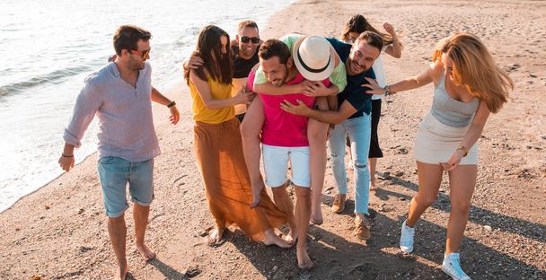 Multiculturele vriendengroep feesten op het strand - Jongeren vieren tijdens de zomervakantie, zomervakantie en feestdagen concepten - Foto, afbeelding