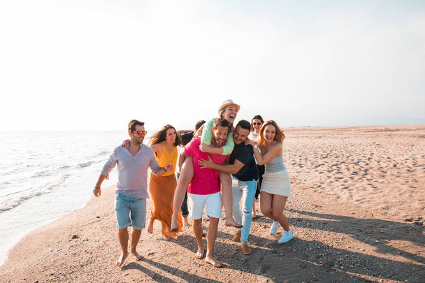 Wielokulturowa grupa przyjaciół imprezujących na plaży - młodzi ludzie świętujący podczas wakacji, wakacji i wakacji - Zdjęcie, obraz
