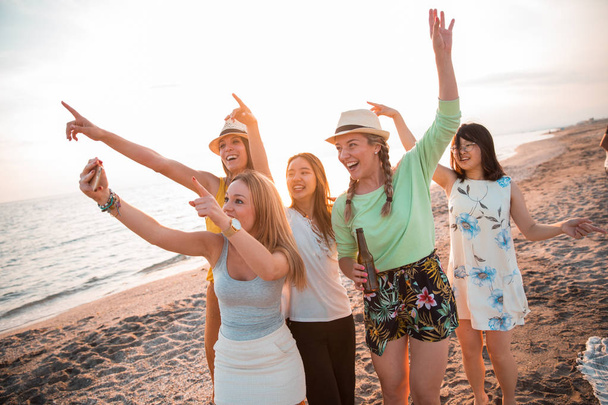 Jovens multirraciais felizes estão fazendo uma selfie na praia enquanto estão em uma festa de verão. Conceito de amigos e férias
 - Foto, Imagem