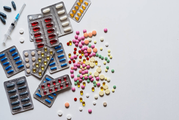 Heap of blisters of colorful pills on a white background. Flat lay. - Photo, image