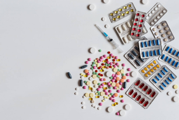 Heap of blisters of colorful pills on a white background. Flat lay. - Foto, imagen