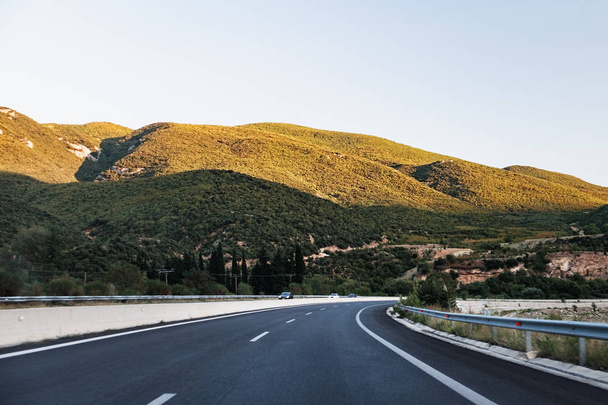 No hay coches, auto en la carretera de asfalto a través de bosques verdes, árboles, pinos, abetos y montaña en Grecia
 - Foto, imagen