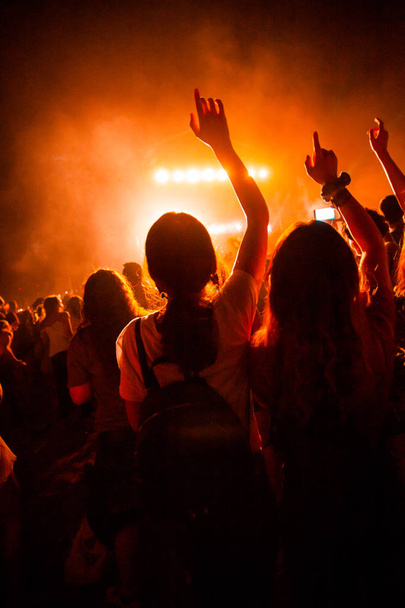 Vista de um concerto com pessoas ou público com as mãos no ar e aplausos em um festival de música. Festival de música de verão
. - Foto, Imagem
